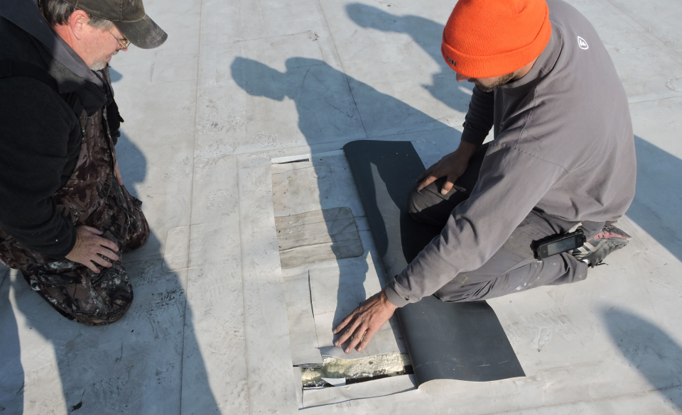 Roofing consultants taking a core sample of commercial roof